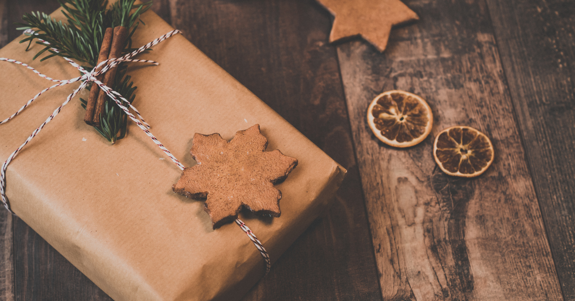 Gift wrapped in brown paper with cinnamon and foliage tied to it