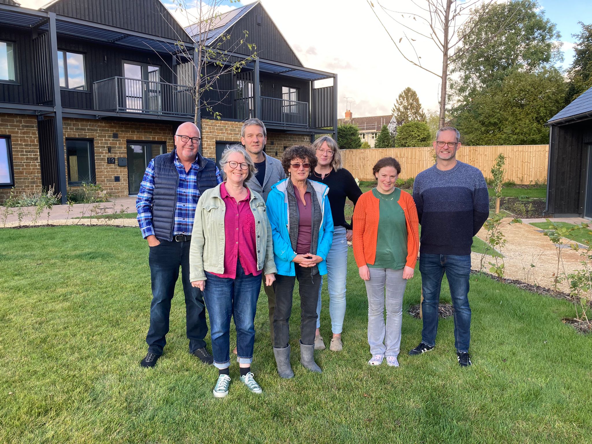 Group of people standing in front of houses at the Bourne Green project