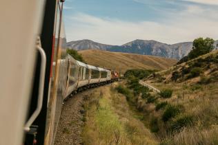 View from a train window as it goes around a bend in a hilly environment