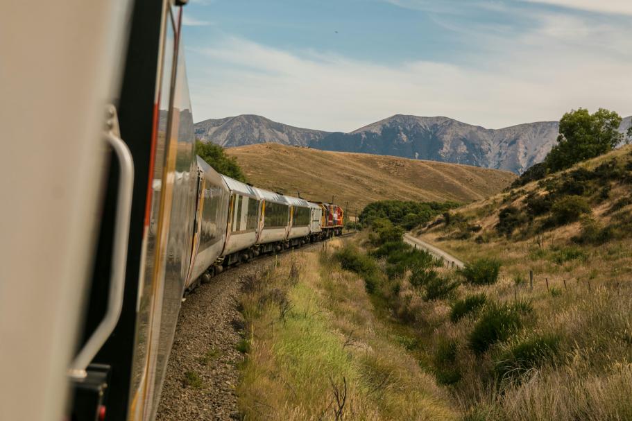View from a train window as it goes around a bend in a hilly environment