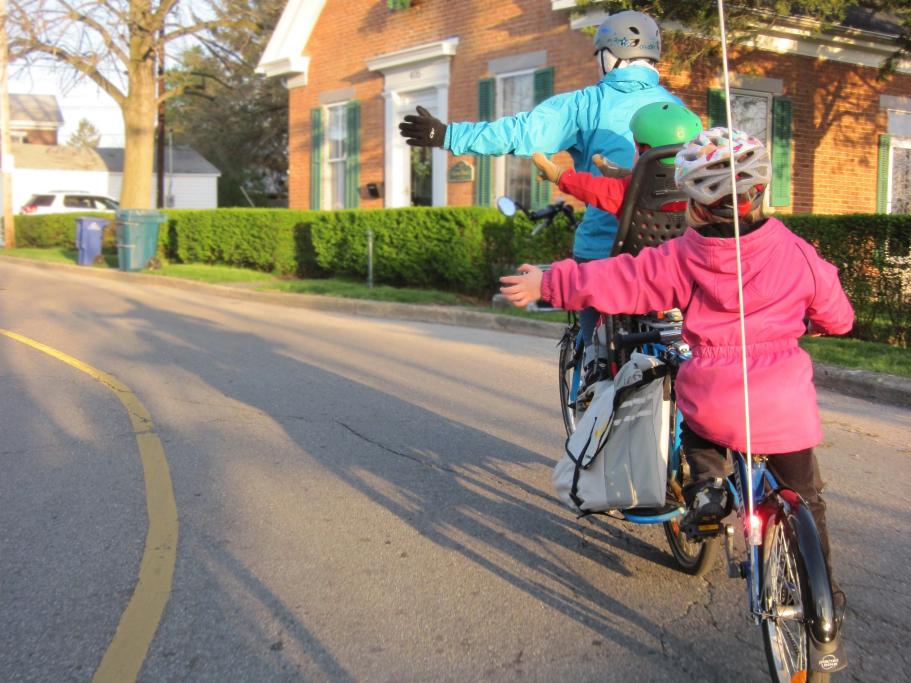 children cycling to school with guardian
