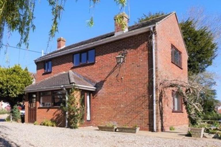 A red-brick, detached house with no renovations or modifications made.