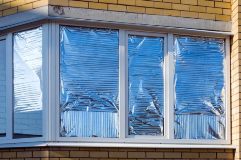Silver foil taped to the inside of the window of a building.
