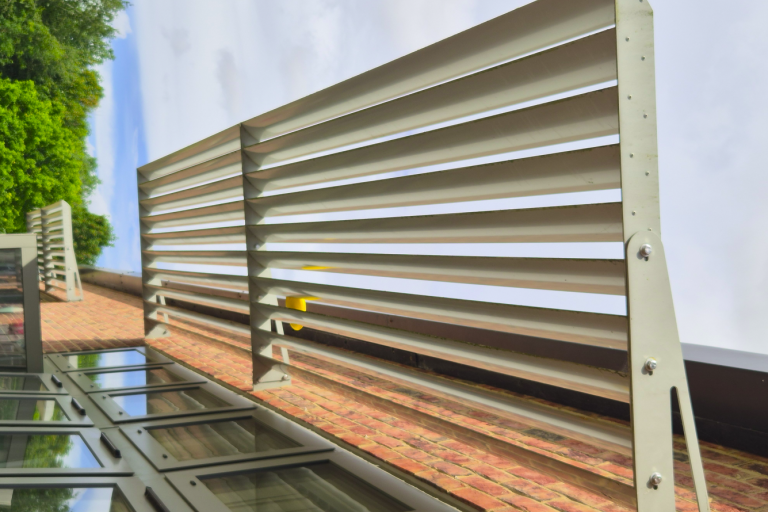 An up-close image of shades installed above the exterior of classroom windows.