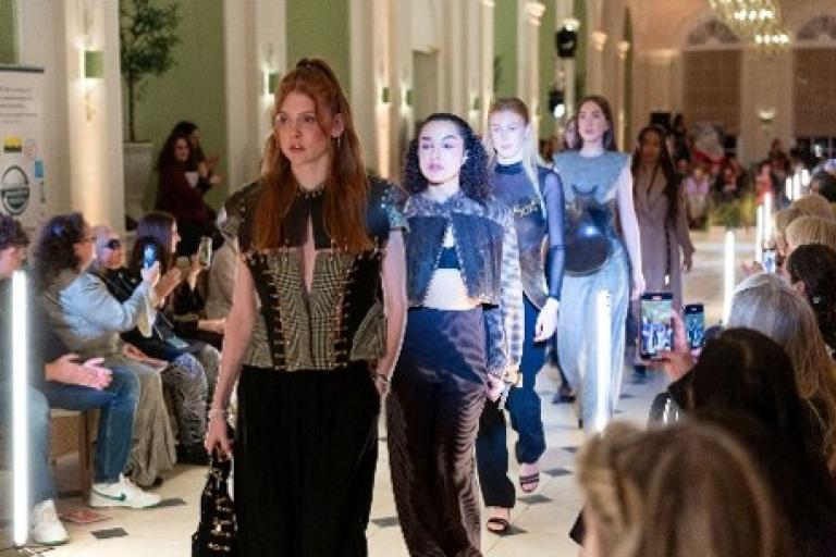 Models walk down a runway.